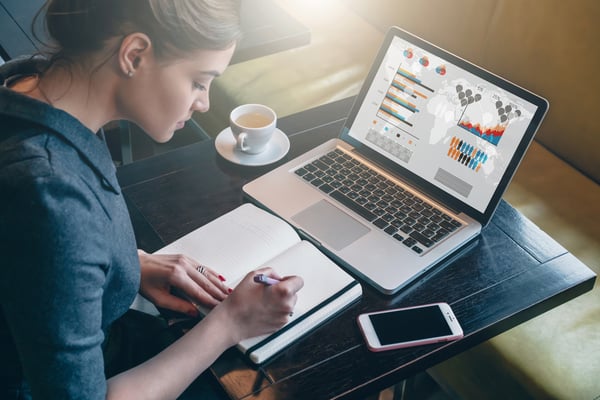 Woman on computer taking notes